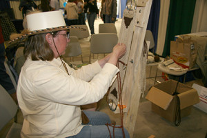 Vendors at the Western States Horse Expo, June 5-7 in Sacramento, California, often give demonstrations alongside their booths. Here a woman demonstrates the art of making a handmade Western cinch.